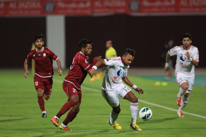 Al Jazira's Khalid Jalal dribbles the ball away from Abdulla Jasem during the Semi-Final Pro League football match between Al Wahda v Al Jazira (white) at Al Wahda's (red) at Al Nahyan Stadium in Abu Dhabi on Monday March 25, 2013. (Ravindranath K / The National)?