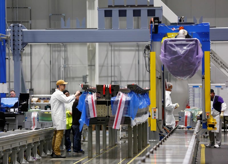 Employees prepare to work on a new set of 777X composite wing panel stringers.