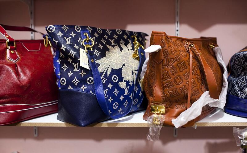 Counterfeit handbags designed by Louis Vuitton and Chanel sit on shelves of a secret room of a store at Karama Market in Dubai.  Andrew Henderson / The National 