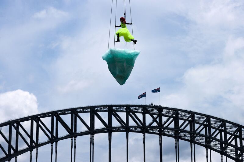 Artist Victoria Hunt performs 'Thaw' atop an 'iceberg' suspended above the Sydney Harbour Bridge, Australia. AFP