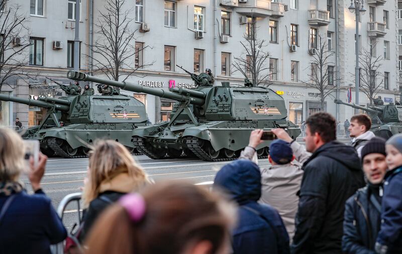 Onlookers watch the heavy military vehicles drive through Moscow. EPA