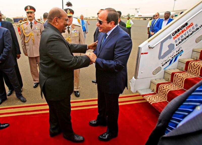 Sudan's President Omar al-Bashir (C-L) embraces his Egyptian counterpart Abdel-Fattah al-Sisi (C-R) upon the latter's arrival at Khartoum International Airport outside the Sudanese capital on October 25, 2018.  / AFP / ASHRAF SHAZLY
