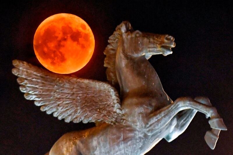 The full moon rises behind the statue of the mythological Pegasus in the city of Corinth, west of Athens. AFP