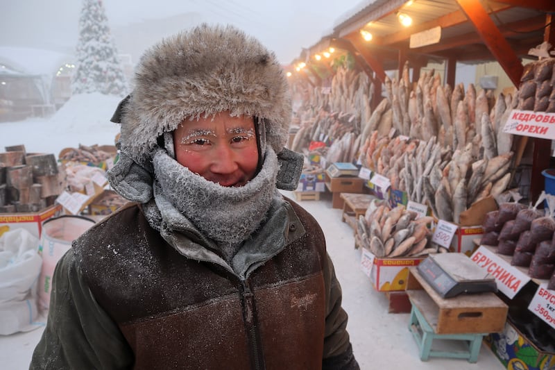 Market vendor Yegor Dyachkovsky sets up his stall in the snow. Reuters