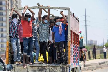 Migrant workers and families onboard a truck crossing the Delhi-Uttar Pradesh border returning home after the goverment eased some of the measures imposed under the  nationwide lockdown imposed to try to stop the spread of Covid-19. AFP