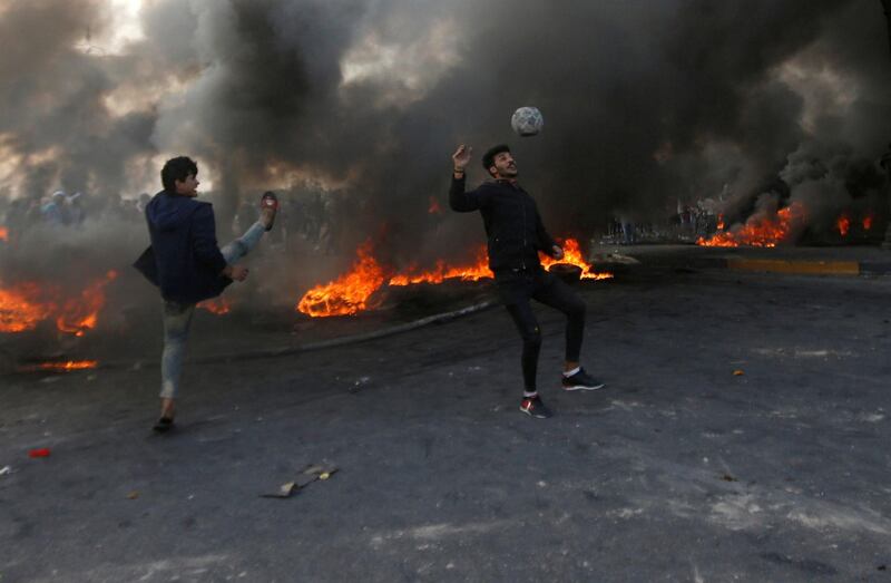 Protesters play football next to burning tyres during ongoing anti-government protests in Basra, Iraq. Reuters