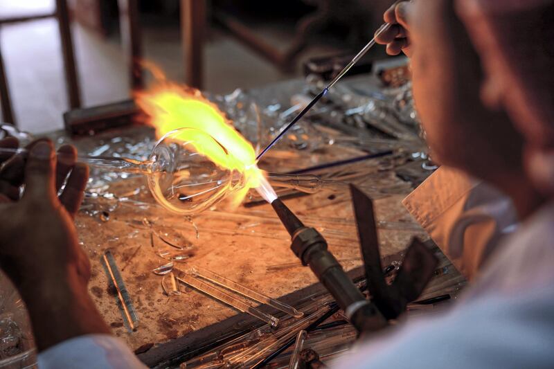 Abu Dhabi, United Arab Emirates, July 23, 2019.  VB:  Photo project at the Heritage Village, Corniche.  Local craftsworkers conduct workshops in traditional metalwork, pottery, glass blowing and Arabic cloak making. --  Noor Ahmad-47, Arabic glass blowing artist busy in his workshop at Heritage Villlage.
Victor Besa/The National
Section:  NA
Reporter: