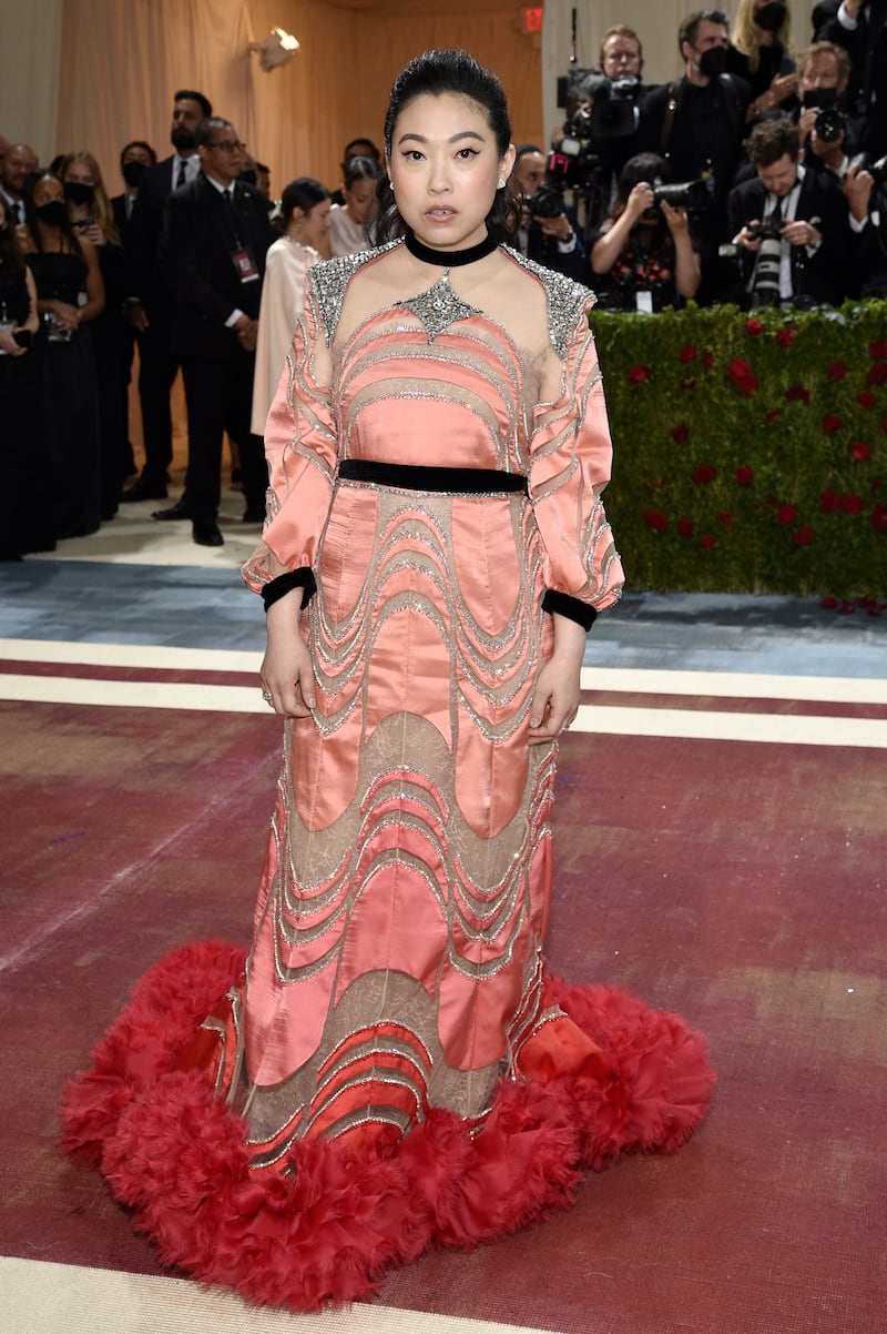 Awkwafina, wearing a peach to red ombre gown. AP Photo