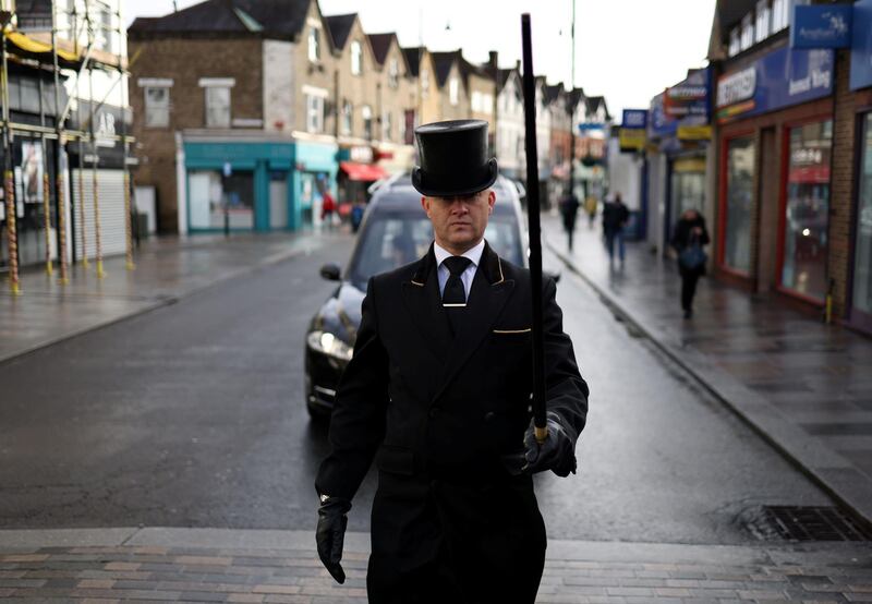W. Uden &amp; Sons Funeral Conductor Spencer Baxter leads the procession of a funeral service in Sidcup, amid the coronavirus disease pandemic, in south east London. Reuters