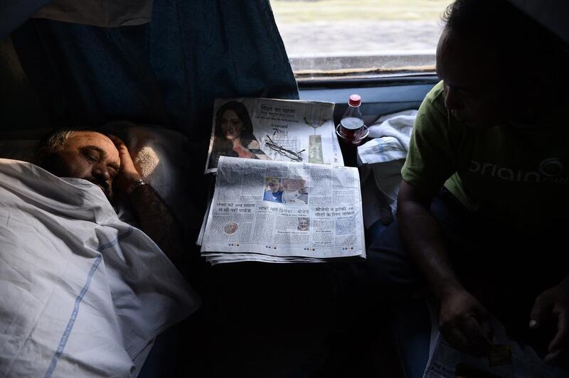 An Indian man asleep in an air-conditioned compartment on board the Kalka Mail train.