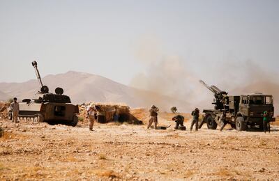 FILE PHOTO:Hezbollah fighters stand near military tanks in Western Qalamoun, Syria August 23, 2017. REUTERS/Omar Sanadiki/File Photo