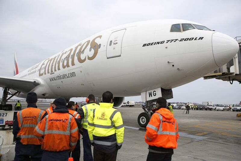 Workers watch as flight EK237 of Emirates Airline parks Logan International Airport in Boston. AP Photo / The Boston Globe / Jessica Rinaldi