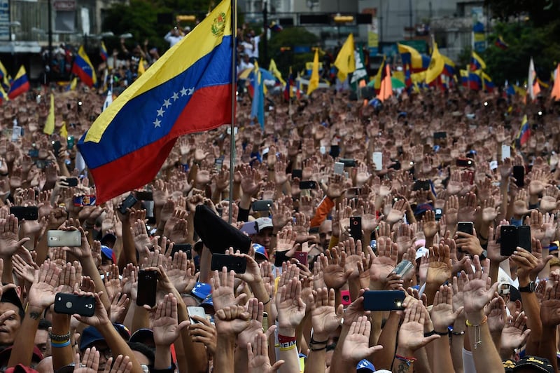 - AFP PICTURES OF THE YEAR 2019 - 

People raise their hands during a mass opposition rally against President Nicolas Maduro in which Venezuela's National Assembly head Juan Guaido (out of frame) declared himself the country's "acting president", on the anniversary of a 1958 uprising that overthrew a military dictatorship, in Caracas on January 23, 2019. - "I swear to formally assume the national executive powers as acting president of Venezuela to end the usurpation, (install) a transitional government and hold free elections," said Guaido as thousands of supporters cheered. Moments earlier, the loyalist-dominated Supreme Court ordered a criminal investigation of the opposition-controlled legislature. (Photo by Federico PARRA / AFP)
