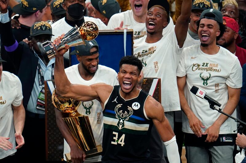 Milwaukee Bucks forward Giannis Antetokounmpo holds with the championship trophy after defeating the Phoenix Suns.