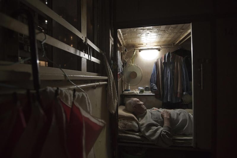 Tse Chu, a retired waiter, sleeps in his little cubicle home in Hong Kong where rents and home prices have steadily risen and are now at or near all-time highs.