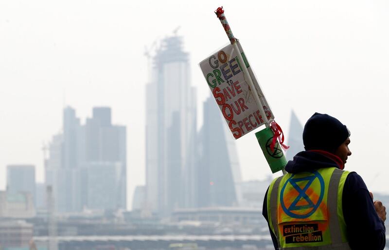 A climate change activist holds a placard at Waterloo Bridge during the Extinction Rebellion protest in London, Britain April 16, 2019. REUTERS/Peter Nicholls