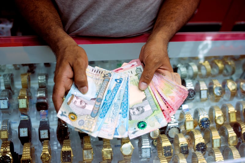 FILE PHOTO: A shopkeeper counts his daily cash in Bahraini dinars as he opens his shop in downtown Manama, Bahrain, June 27, 2018. REUTERS/Hamad I Mohammed/File Photo