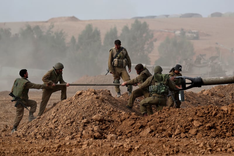 Israeli artillery soldiers clean a cannon at an area on the border with Gaza, southern Israel. EPA