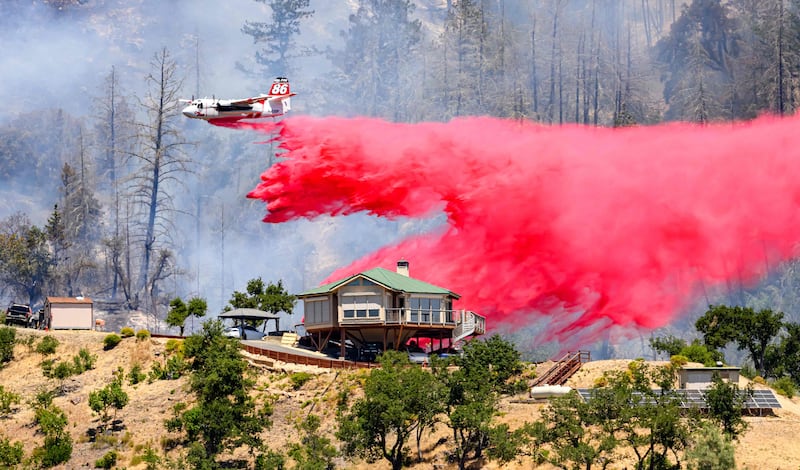 An air tanker drops fire retardant over a house during the Toll fire in Calistoga, California. AFP