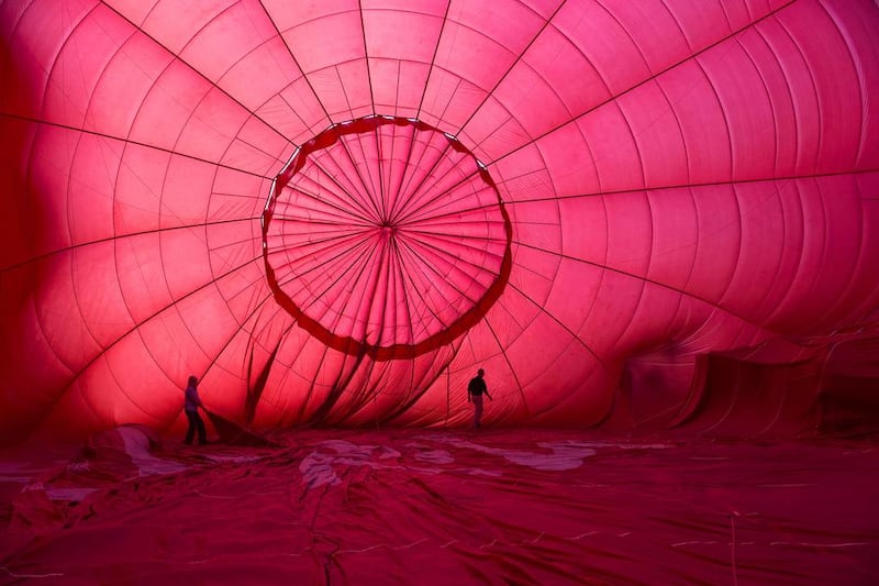 Balloonists roll out the canvas of this red balloon