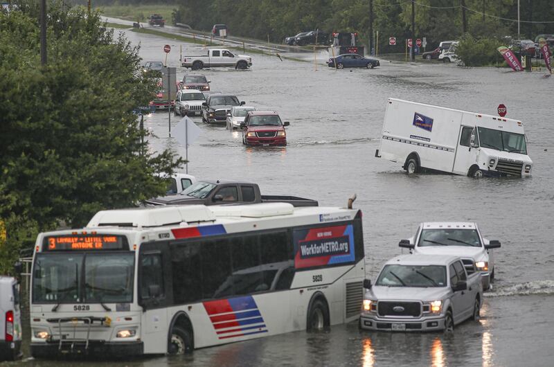 Cars are flooded as people walk though the flooded street of Little York on September 19, 2019 in Houston, Texas.&nbsp;AFP
