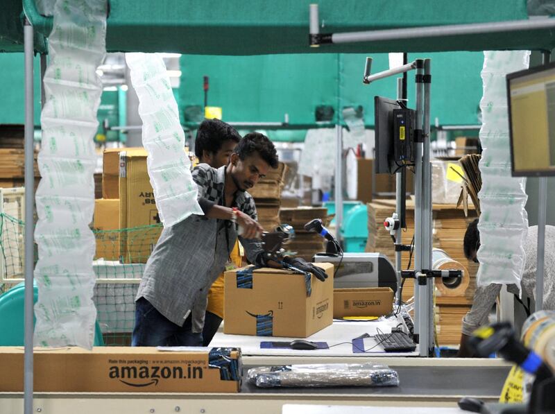 Indian employees work inside Amazon's largest Fulfillment Centre (FC) in India, on the outskirts of Hyderabad on September 7, 2017. / AFP PHOTO / NOAH SEELAM