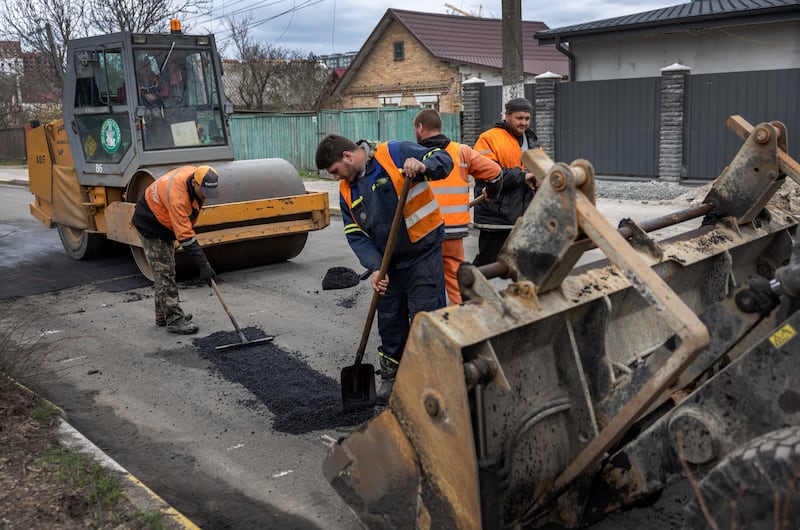 City workers repair a war-damaged road in Bucha. Getty Images