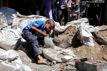 A Yemeni boy searches a street in Taez city for bullet casings to sell as scrap metal, on April 27, 2019. AFP