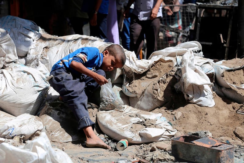 A Yemeni boy looks for bullet casings, to sell as scrap metal, in a street in an old market on April 27, 2019, in Yemen's third city of Taiz after clashes between pro-government militias left two children dead.  / AFP / Ahmad AL-BASHA
