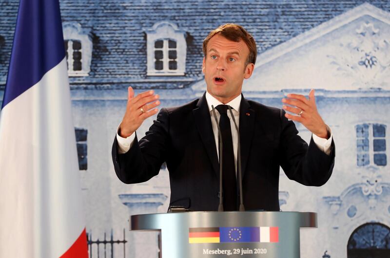 French President Emmanuel Macron gestures as he gives a press conference after a bilateral meeting with German Chancellor Angela Merkel, at the German government's guest house Meseberg Castle in Gransee near Berlin, Germany, Monday, June 29 2020. The meeting takes place ahead of Germany's EU Council Presidency in the second half of 2020. (Hayoung Jeon, Pool via AP)