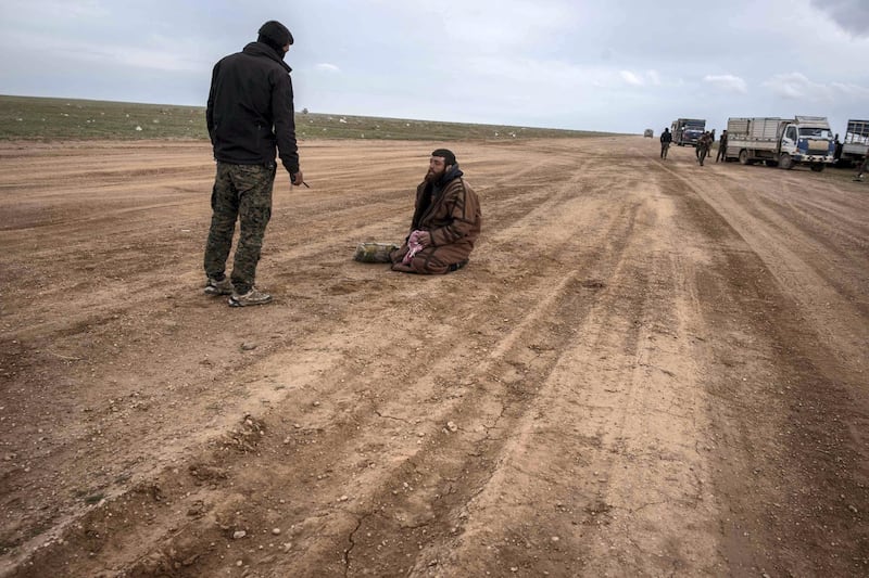 A suspected ISIS member is questioned by a member of the Syrian Democratic Forces outside Baghouz, Syria, 28 February 2019. Campbell MacDiarmid