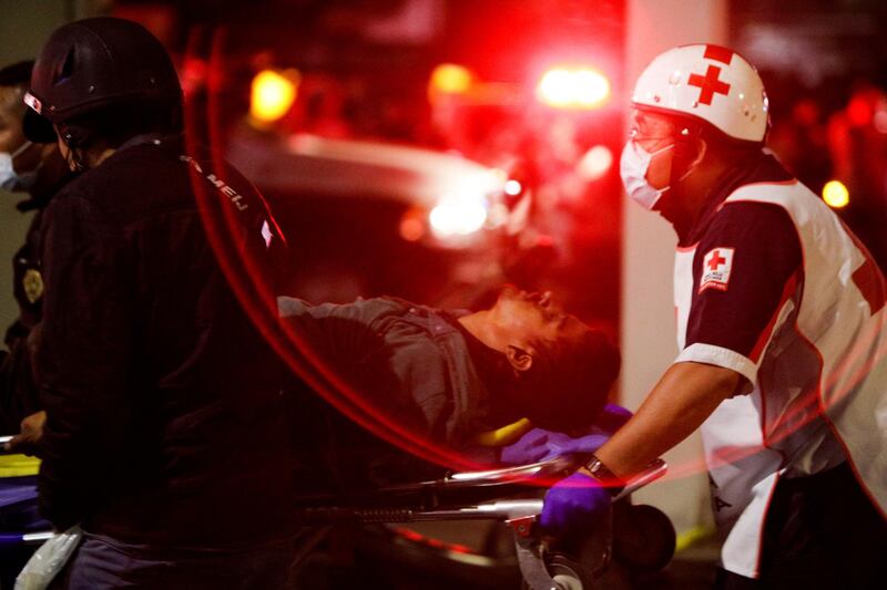 Rescuers transport a casualty on a stretcher at a site where an overpass for a metro partially collapsed with train cars on it at Olivos station in Mexico City. Reuters