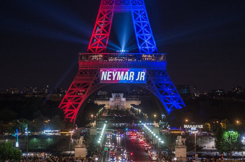 epa06127465 The Eiffel Tower is illuminated in Red and blue (the colors of the Paris Saint Germain soccer team) to celebrate the arrival of the Brazilian striker Neymar Jr on the day of his official presentation to the public during the French Ligue 1 soccer match between Paris Saint-Germain (PSG) and Amiens SC in Paris, France, 05  August 2017 (issued 06 August 2017).  EPA/CHRISTOPHE PETIT TESSON