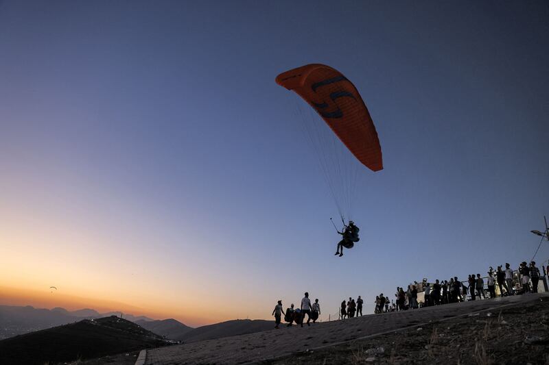 Members of the Sulaymaniyah paragliding team launch at sunset from Mount Azmar to glide over the city of Sulaymaniyah in north-eastern Iraq's autonomous Kurdistan region.