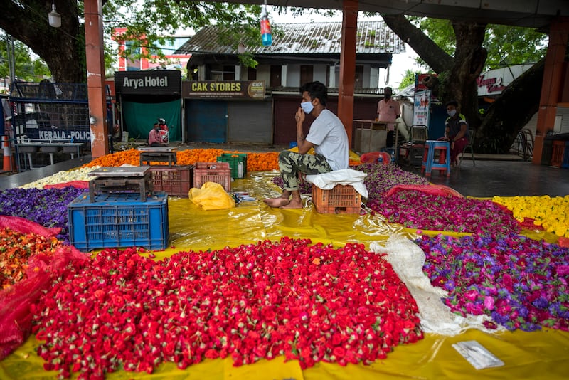 A flower vendor awaits customers at a temporary stall during Onam festivities in Kochi, Kerala. AP