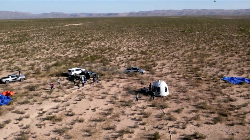 The capsule of Blue Origin’s New Shepard mission NS-18 is surrounded by ground crew after landing by parachute near Van Horn, Texas, in a still image captured from video. Reuters