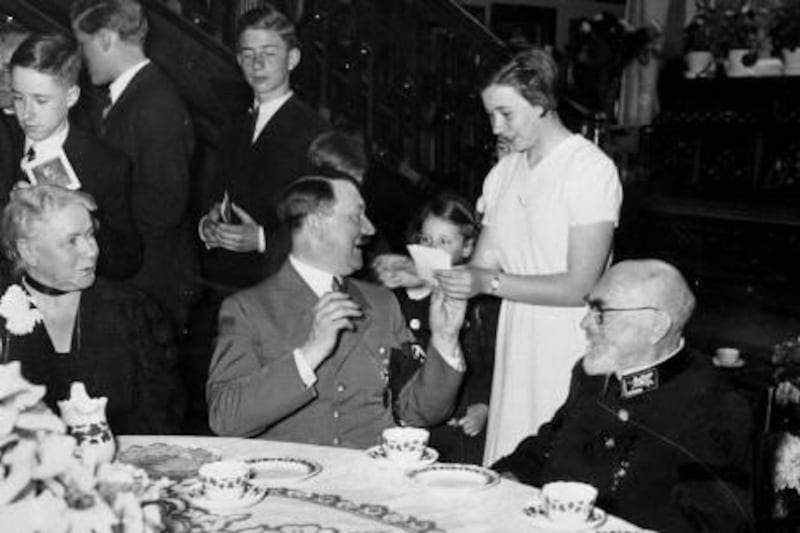 German Chancellor Adolf Hitler, center, gives his autograph to the great-granddaughter of German industrialist Emil Kirdorf, seated at right, on the occasion of Kirdorf's 90th birthday in Berlin, Germany, April 8, 1937.  Hitler presented Kirdorf with the