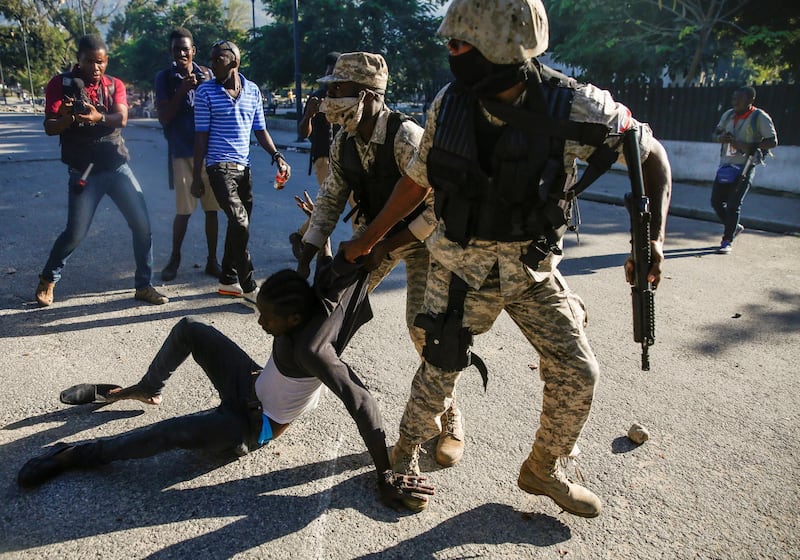 Police officers detain a man during protests against Haiti's President Jovenel Moise, in Port-au-Prince, Haiti February 8, 2021. REUTERS/Jeanty Junior Augustin