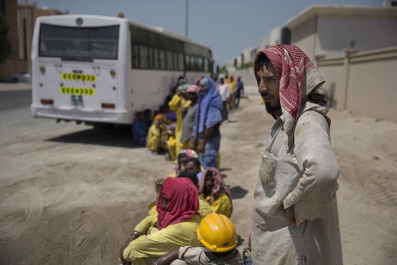 Labourers wait for their bus in the summer heat as the three-hour midday break kicks in. Doctors have warned rising temperatures linked to climate change will lead to health problems for construction workers and the wider population. Silvia Razgova/The National