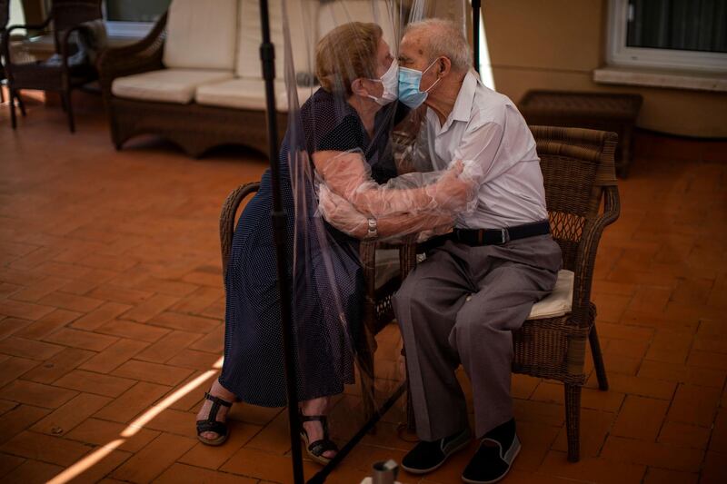 Agustina Canamero, 81, and Pascual Perez, 84, hug and kiss through a plastic film screen to avoid contracting the coronavirus at a nursing home in Barcelona, Spain, on June 22, 2020. AP Photo