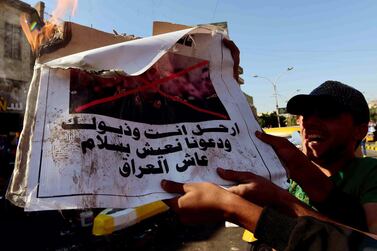 Iraqi protesters burn a portrait of General Qasem Soleimani, who heads the elite Quds Force of Iran's Revolutionary Guard with slogan reading in Arabic 'Leave, with your tails and let us live in peace long live Iraq' during the ongoing protests in Baghdad, Iraq, 18 November 2019. EPA