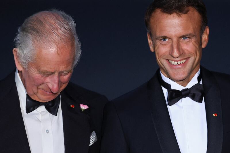 King Charles and Mr Macron share a joke. Reuters