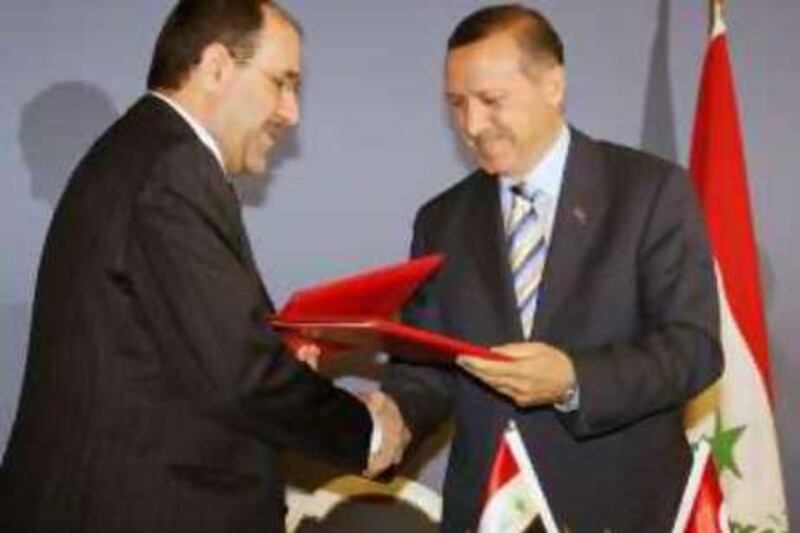 Iraqi Prime Minister Nouri al-Maliki, left, and his Turkish counterpart Recep Tayyip Erdogan exchange a signed memorandum to speed up work to finalize a counterterrorism agreement after their talks in Ankara, Tuesday, Aug. 7, 2007. Turkey and Iraq agreed to try to root out a Kurdish rebel group from northern Iraq, but Maliki said he would not sign an agreement implementing the promise until it was put to his parliament.(AP Photo/Burhan Ozbilici)