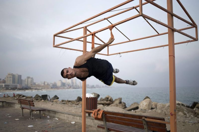 Palestinian Bakr al-Makadmeh, of Bar Palestine group, suspends during street exercises on the coast of Gaza City on August 3. Street workout, which is still new to Gaza, is a growing sport across the world with annual competitions and events.
