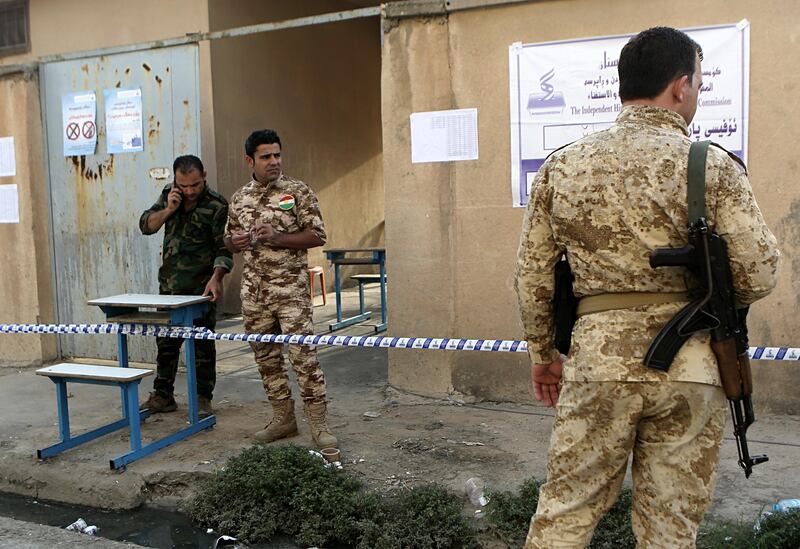 Peshmerga forces stand guard outside a polling centre in Erbil. Khalid Mohammed / AP Photo