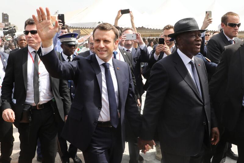 TOPSHOT - French President Emmanuel Macron (L) and Ivorian President Alassane Ouattara (R) arrive to attend a ceremony to lay the first brick of the future Bouake market, which had burnt down 20 years prior, on December 22, 2019, in Bouake, as part of a three-day visit to West Africa. / AFP / Ludovic MARIN
