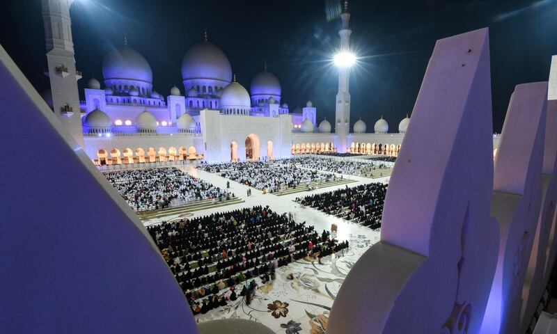 Tens of thousands of worshippers pray at Sheikh Zayed Grand Mosque in Abu Dhabi on Saturday night. The men are dressed mostly in white while the women are dressed in black. Karim Sahib / AFP