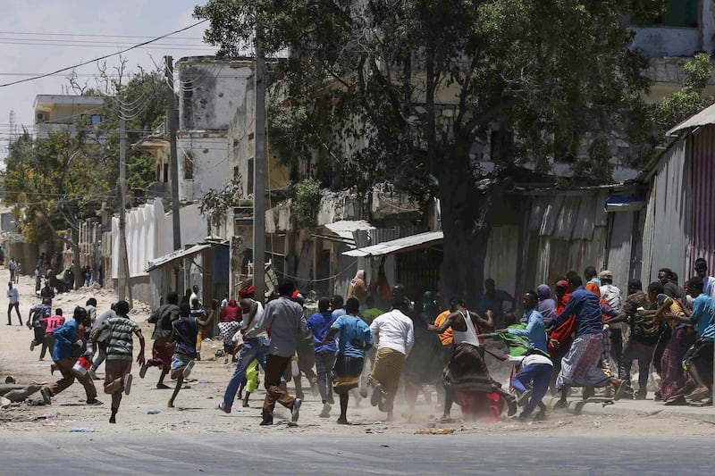 epa07457777 Civilians flee the scene of a gun fight as Somali security forces battle al-Shabab fighters who stormed the government building after exploding a car bomb in central Mogadishu, Somalia, 23 March 2019. Reports say at least four people have been killed in the ongoing attack claimed by the country's Islamist militant group al-Shabab.  EPA/SAID YUSUF WARSAME