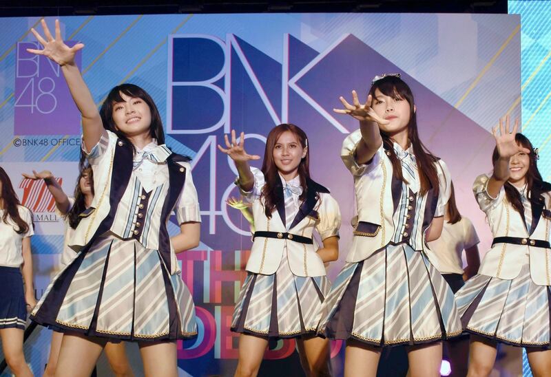 FILE - In this June 2, 2017, file photo, Thai pop band BNK 48 performs for the first time in a large commercial facility in  Bangkok, Thailand. The popular Thai music act BNK 48 has set off a scandal after one of its members wore a shirt showing the swastika flag of Nazi Germany during a performance. (The Yomiuri Shimbun via AP Images)