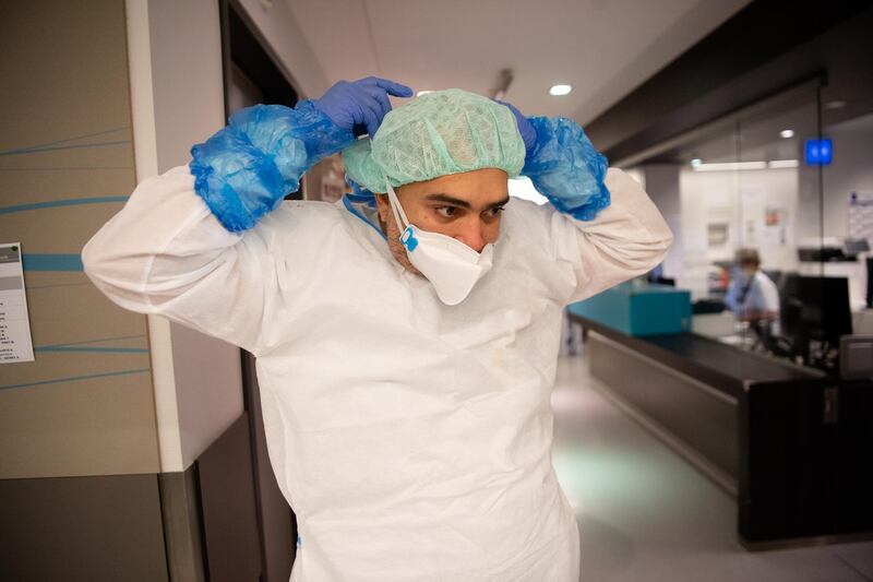 A nurse prepares to enter a Covid-19 room. The unit is understaffed, with what staff they do have now exhausted from the long hours and stressful work. Getty Images